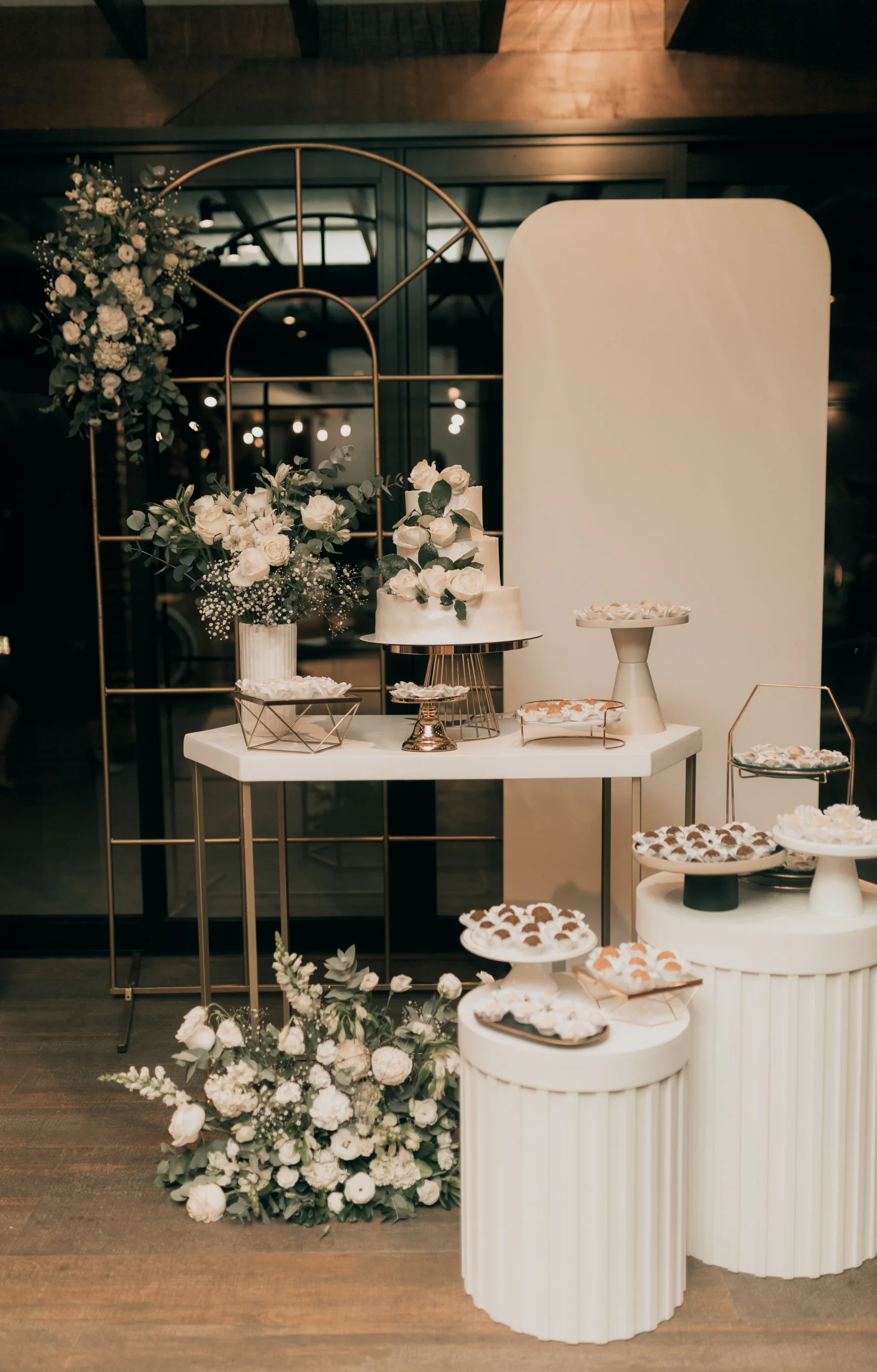 Moderne Hochzeitstorte mit weißen Rosen und Dessertbuffet
